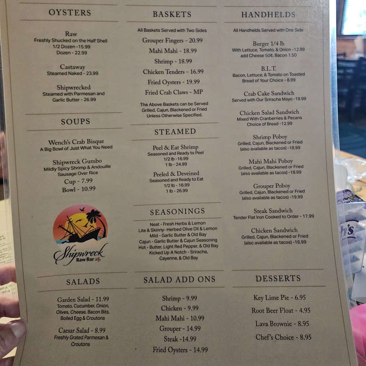 Shipwrecked Raw Bar menu with oysters, baskets, handhelds, soups, steamed, salads, and desserts