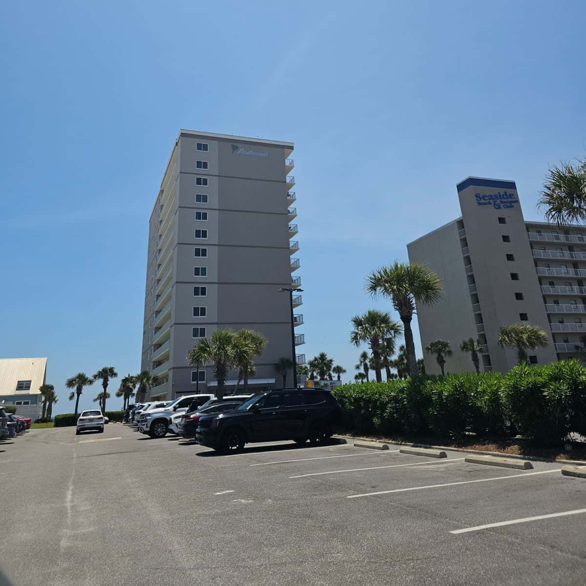 Tradewinds on the top of a multi-story condo building, looking across the parking lot with cars and trucks parked