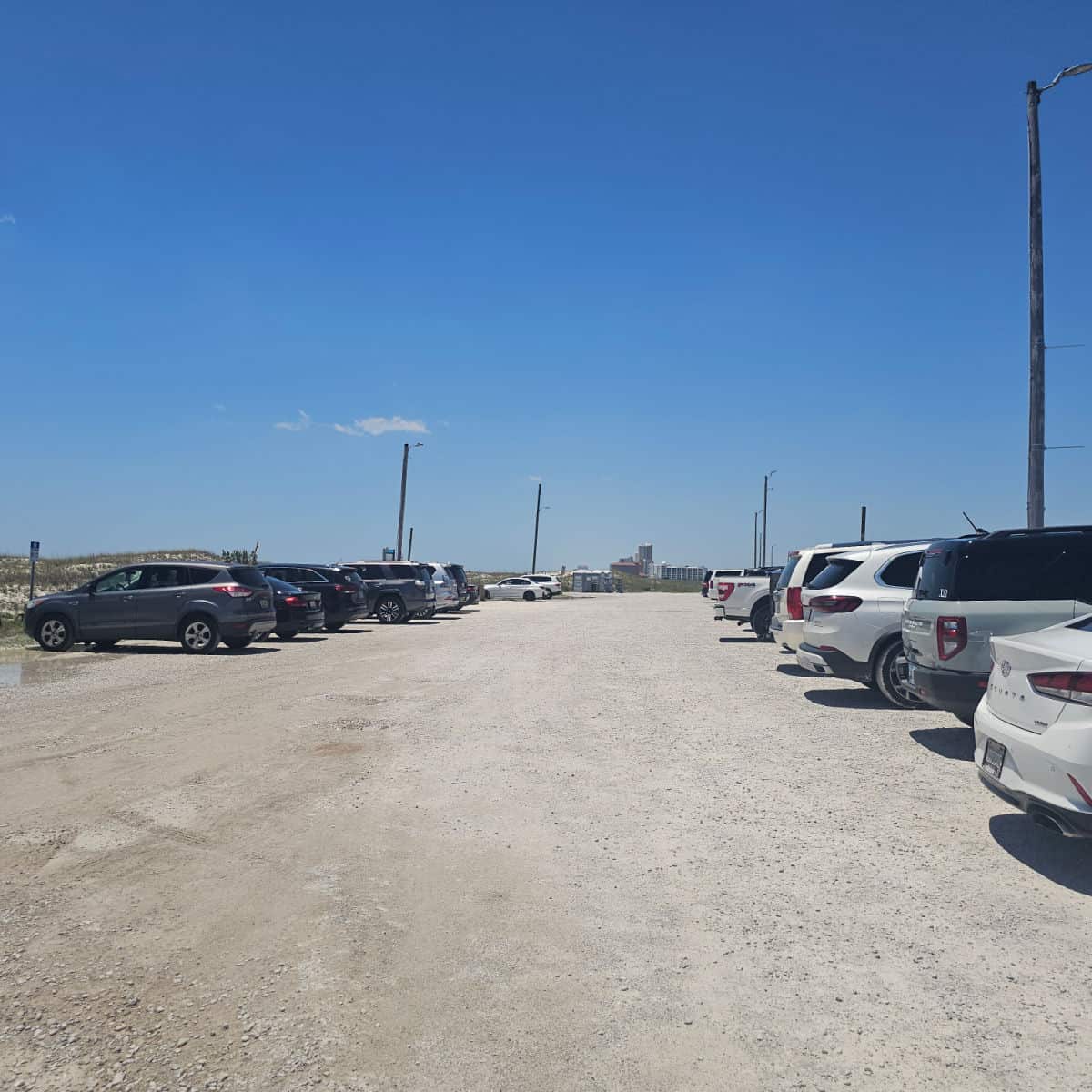 cars lined up in a dirt parking lot