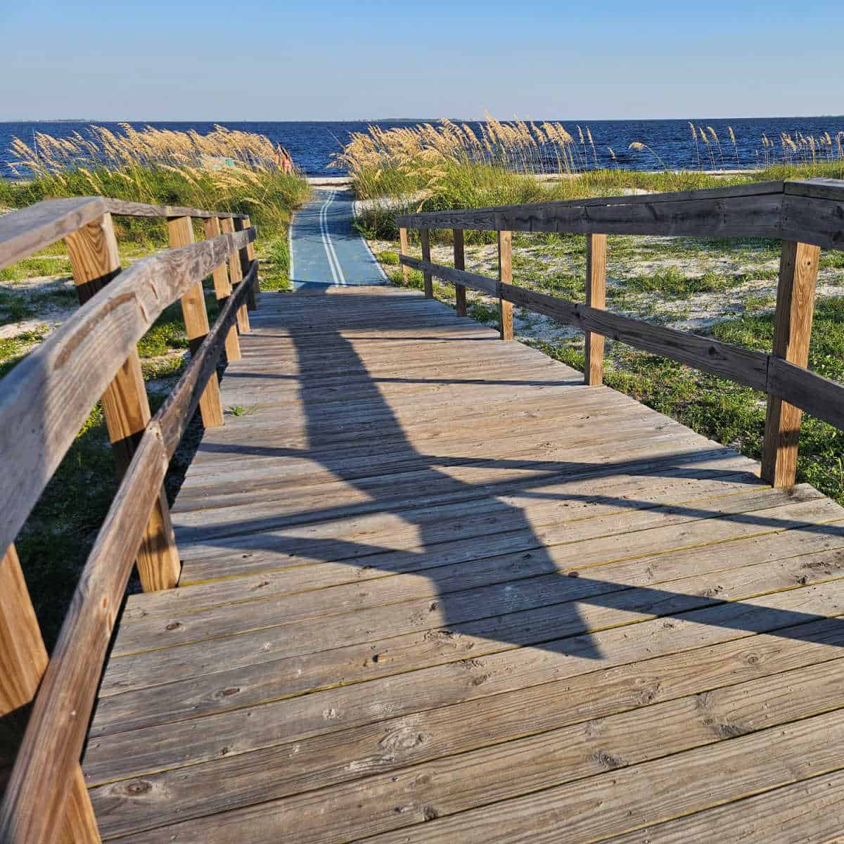 boardwalk leading to an accessibility mat over the sand to the beach, Gulf waters in the background