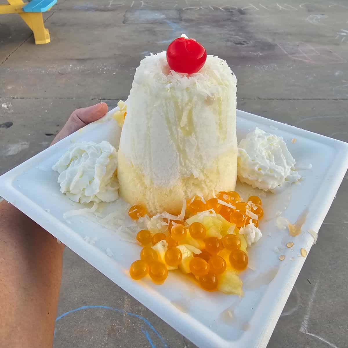 pina colada vampire penguin shaved ice with boba pearls and whipped cream on a white plate