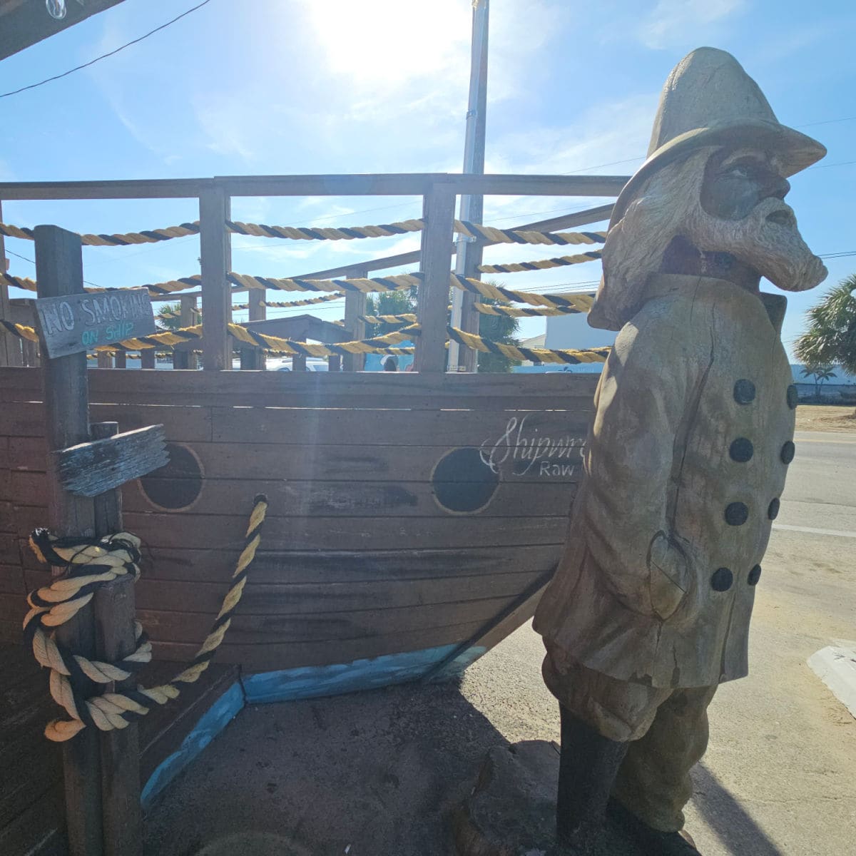 Kids wooden boat play structure with a captain with a yellow rainjacket and hat