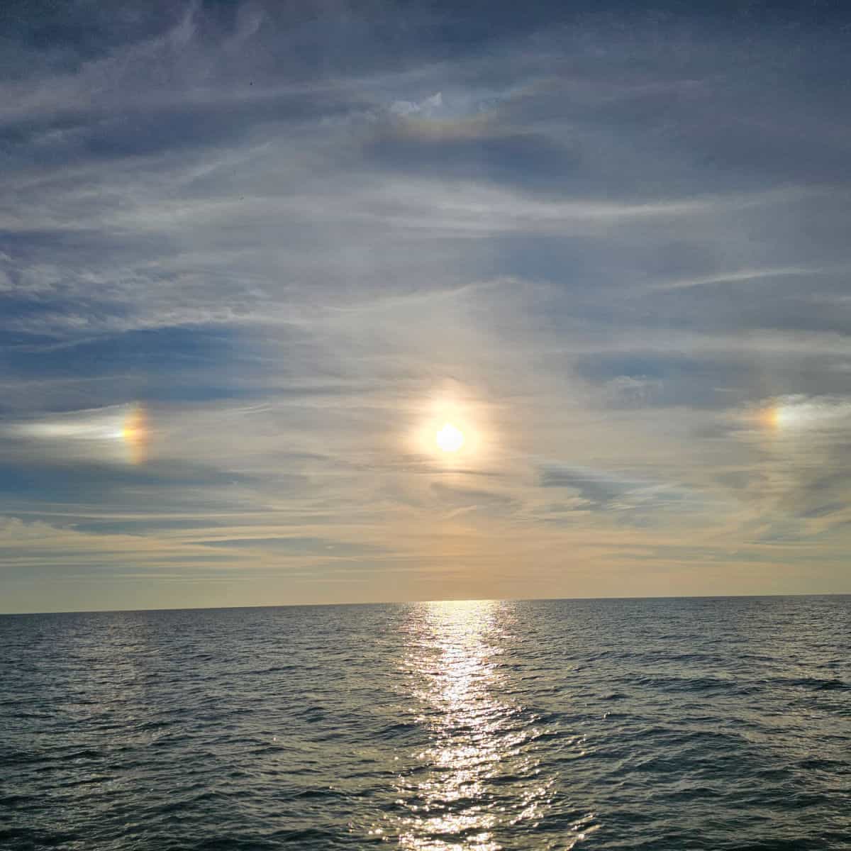 sun and rainbows over the water
