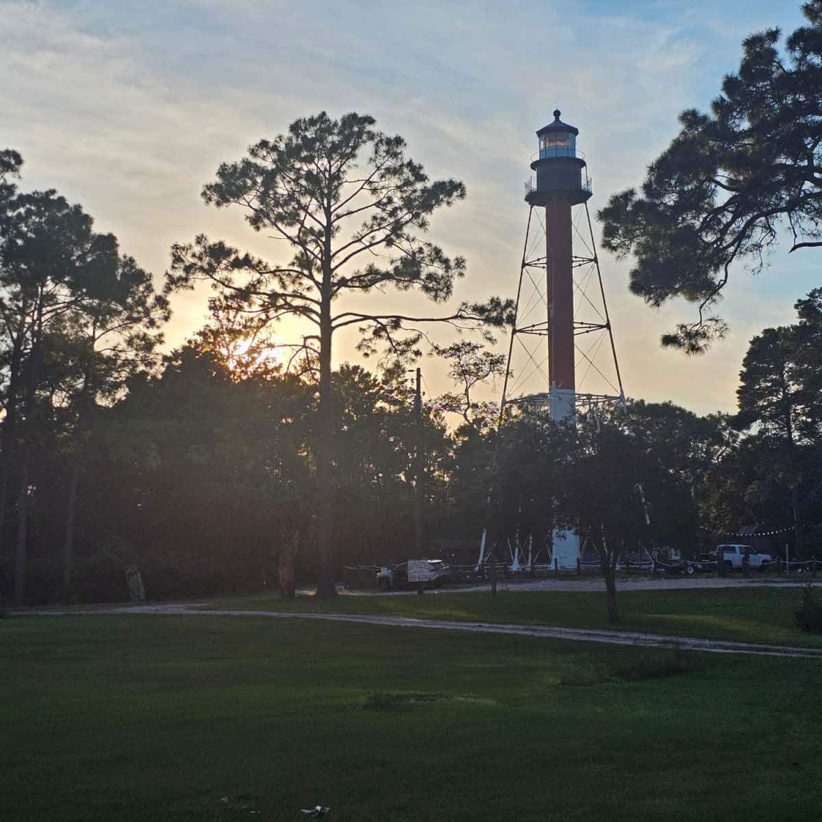 sunset through the trees with the Crooked River Lighthouse in the image