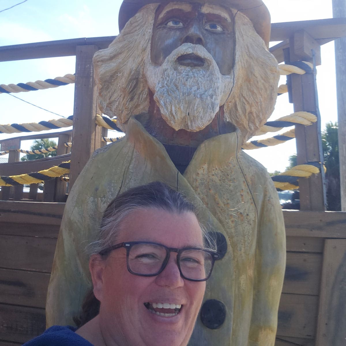 Tammilee standing in front of a pirate in a yellow jacket statue