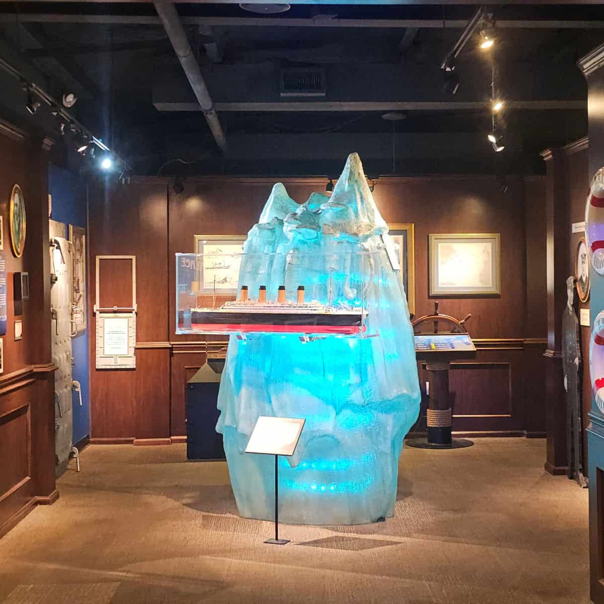 Titanic Ship model next to a large iceberg, wooden walls with Titanic information