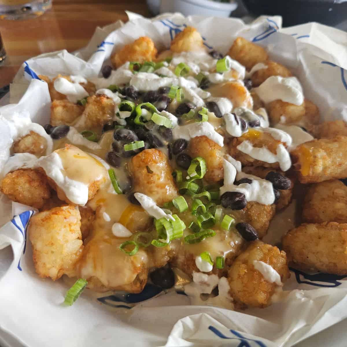 tater tot nachos in a white paper lined basket