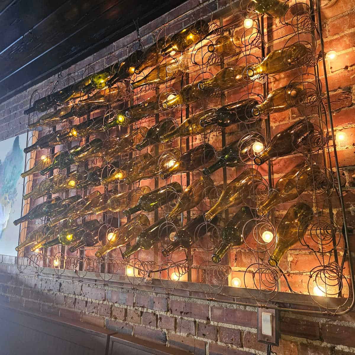 wire mattress turned into a wine rack with lights and wine bottles