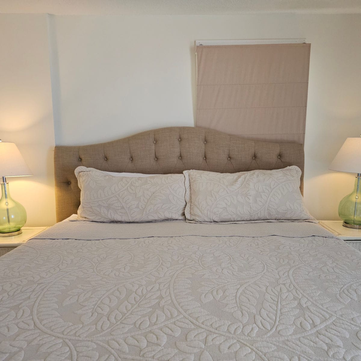 bedroom with a king bed, fabric nightstand, lamps on either nightstand