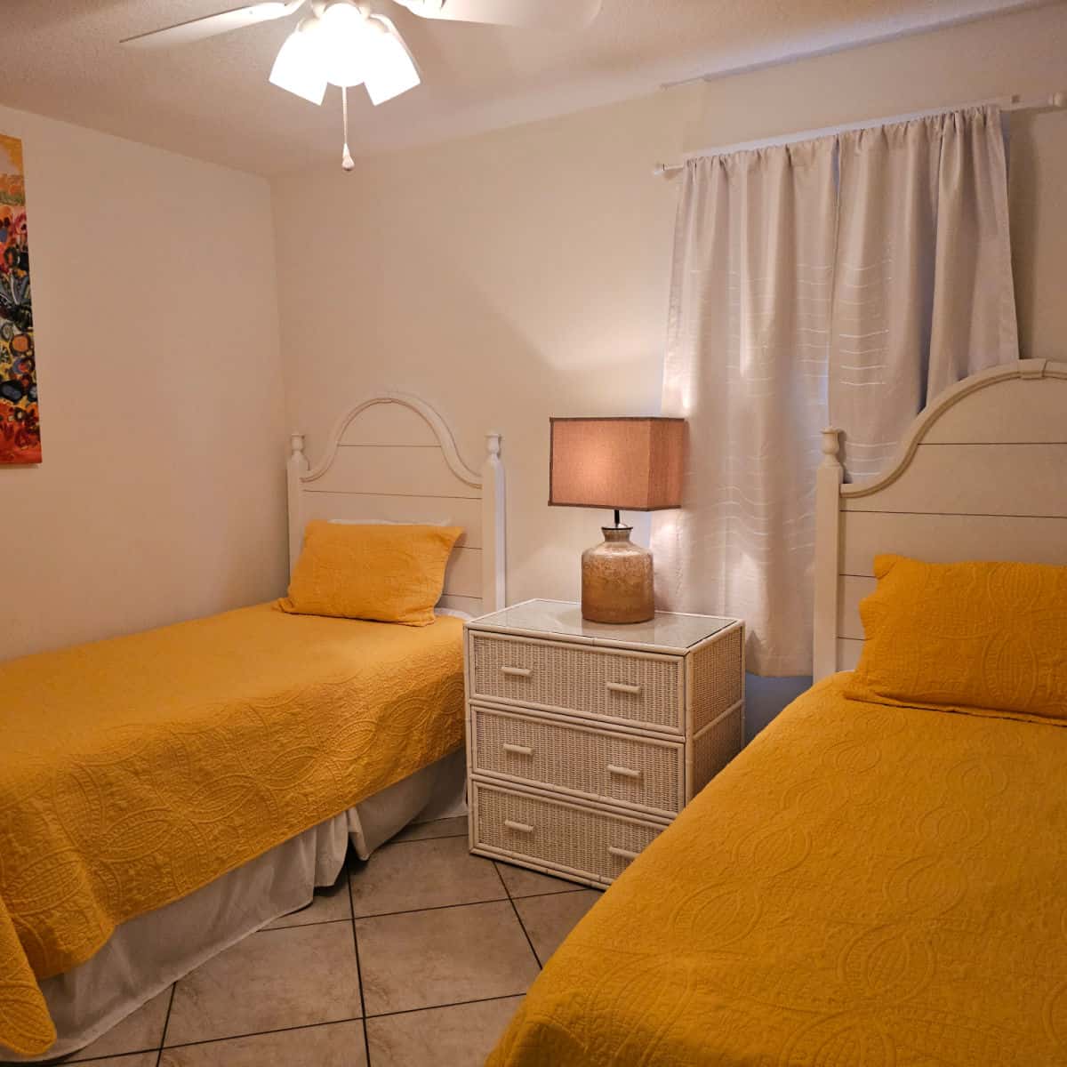 Living room with two beds, yellow covers and a nightstand in the middle of the beds