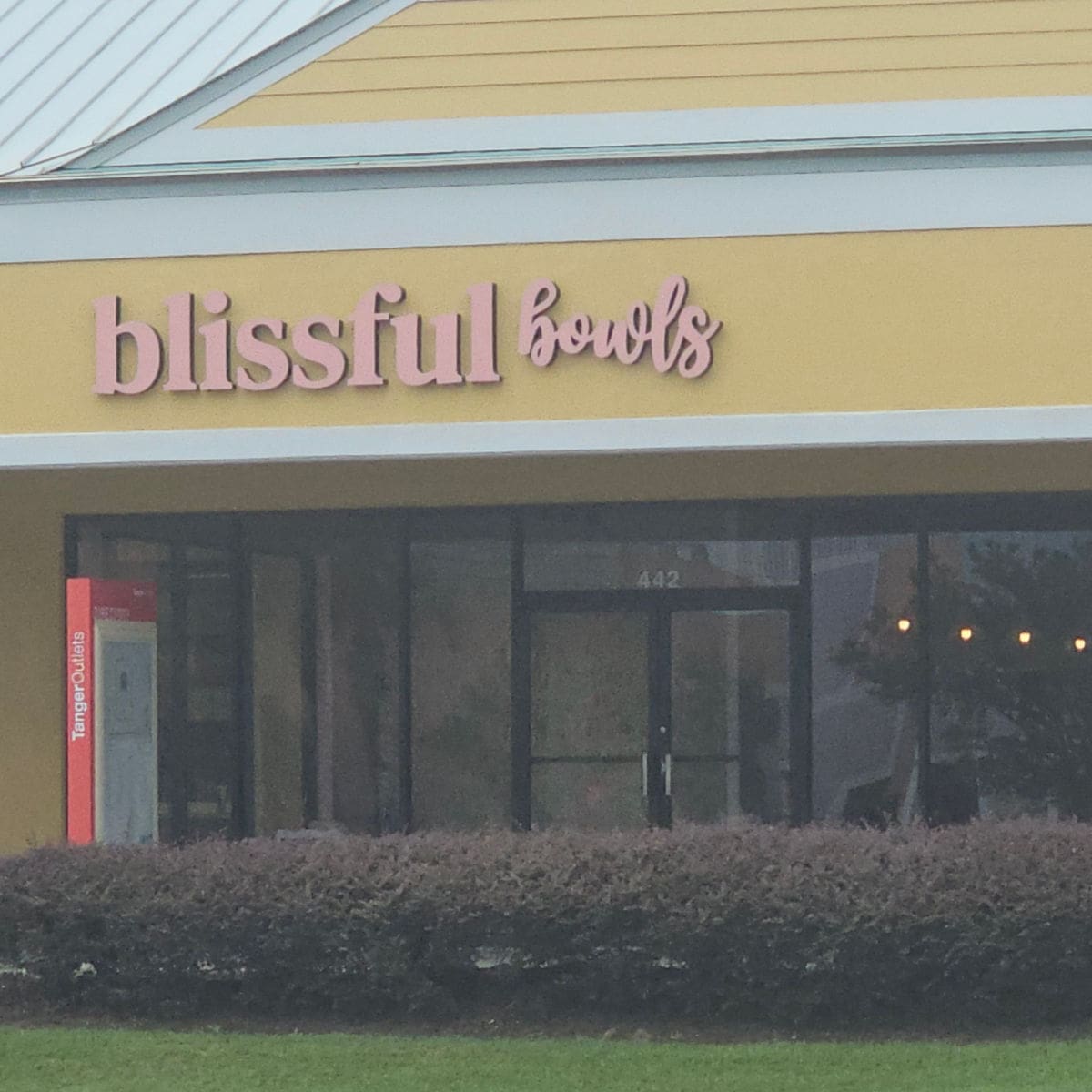 Blissful Bowls sign over the glass door entrance to the restaurant