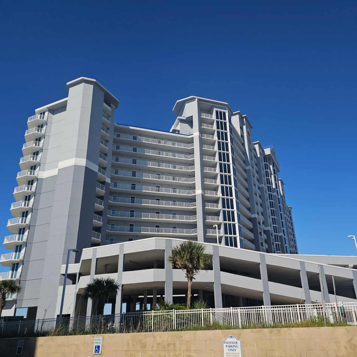 exterior of Lighthouse Condo Building with multiple floors and a multi-story parking garage