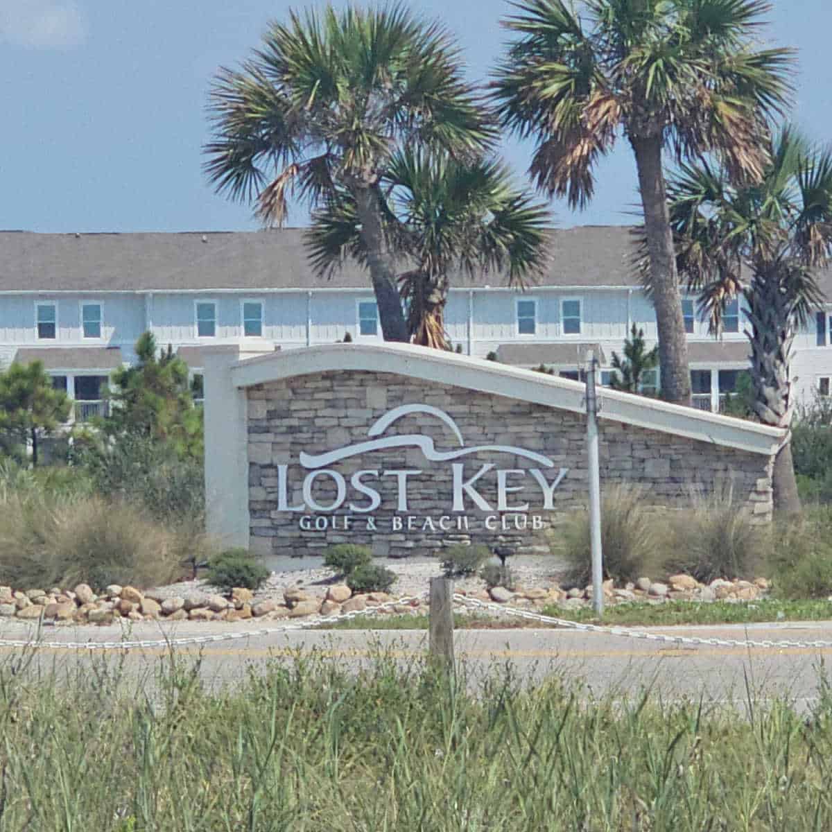 Lost Key Golf & Beach Club sign with palm trees around it