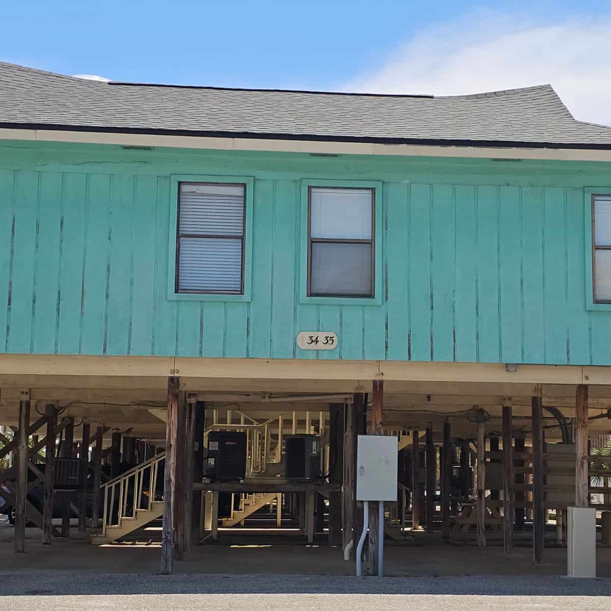 turquoise building with parking uner the building