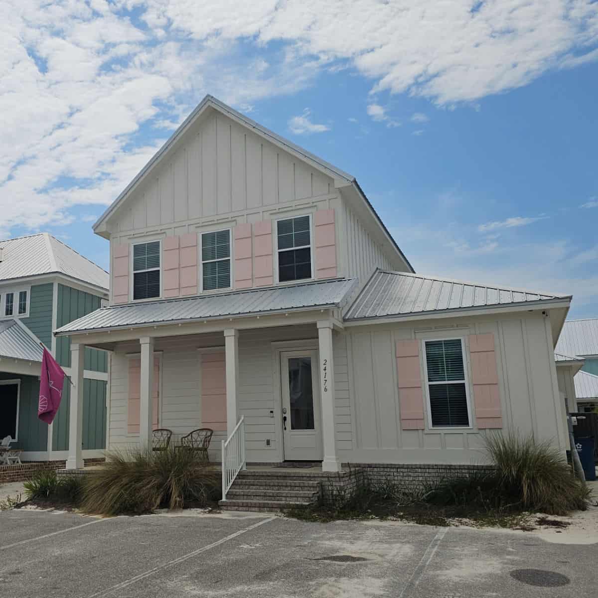 two story white house with pink shutters and a Gulf Babe flag