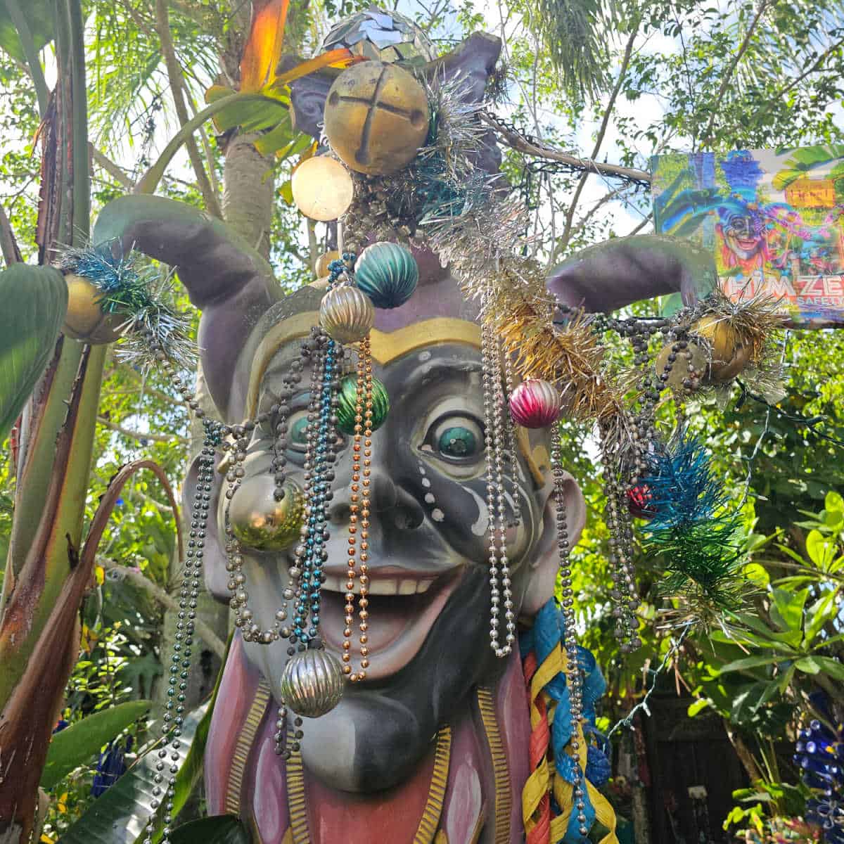 Jester covered in mardi gras beas and ornaments with a Whimzeyland sign