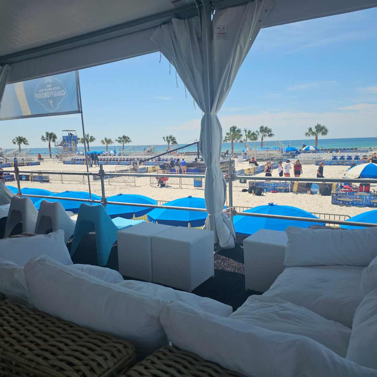 NCAA fan experience seats with couches looking out over the beach volleyball tournament
