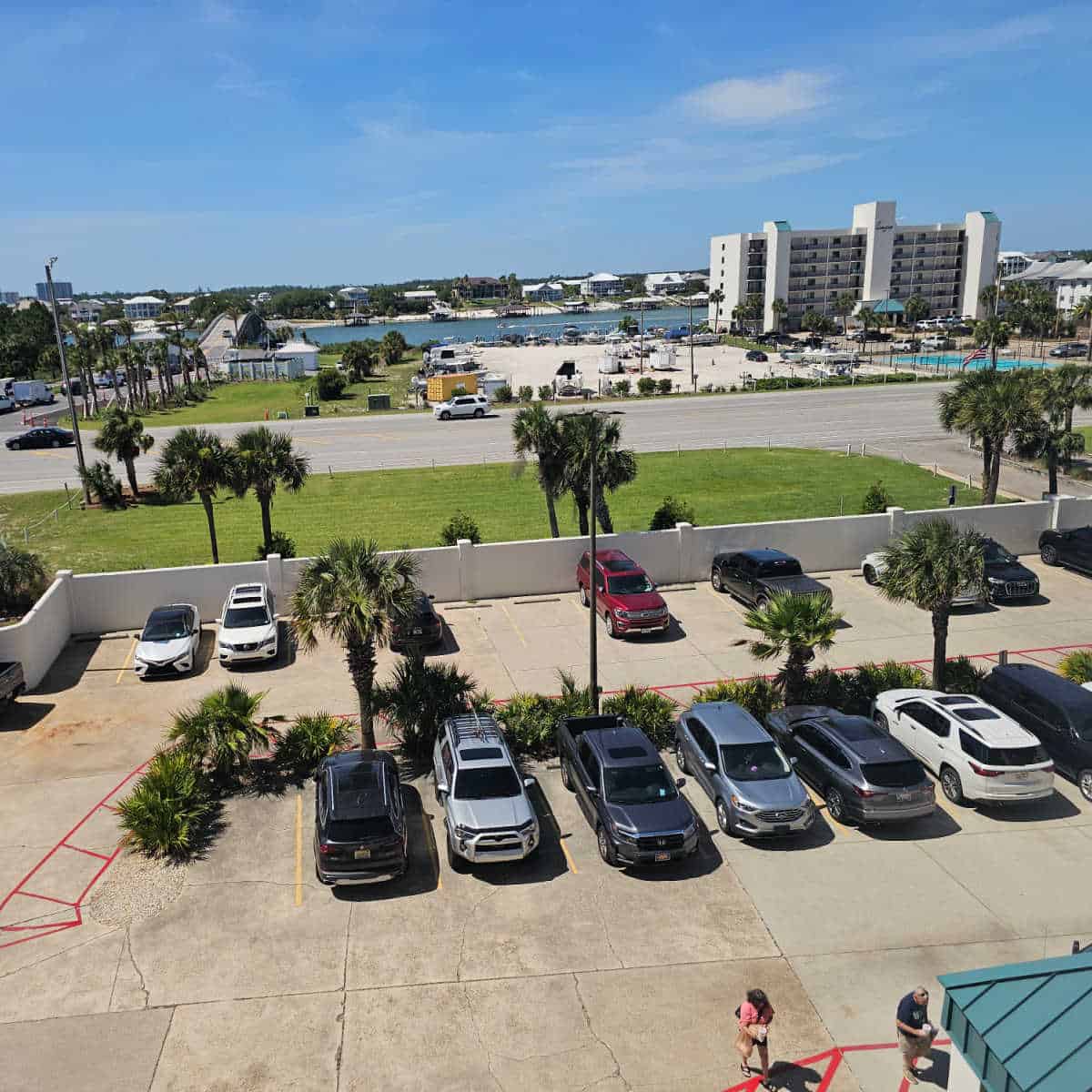 parking area for Wind Drift with cars in rows looking over the main road to additional buildings