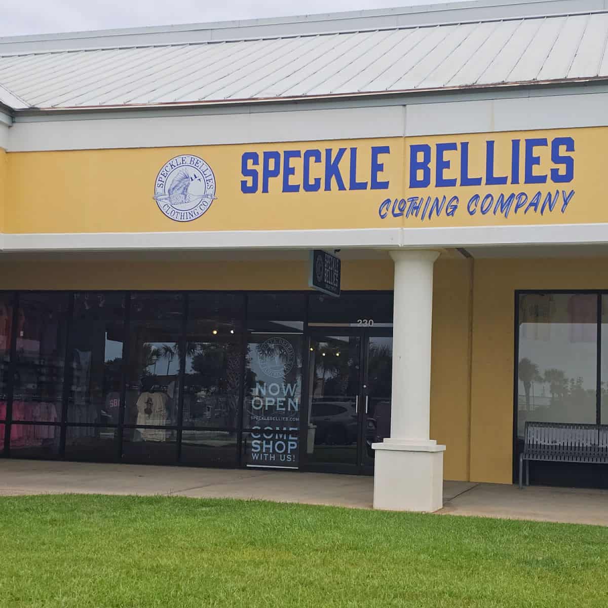Speckle Bellies Clothing Company sign over the entrance to the store and now open