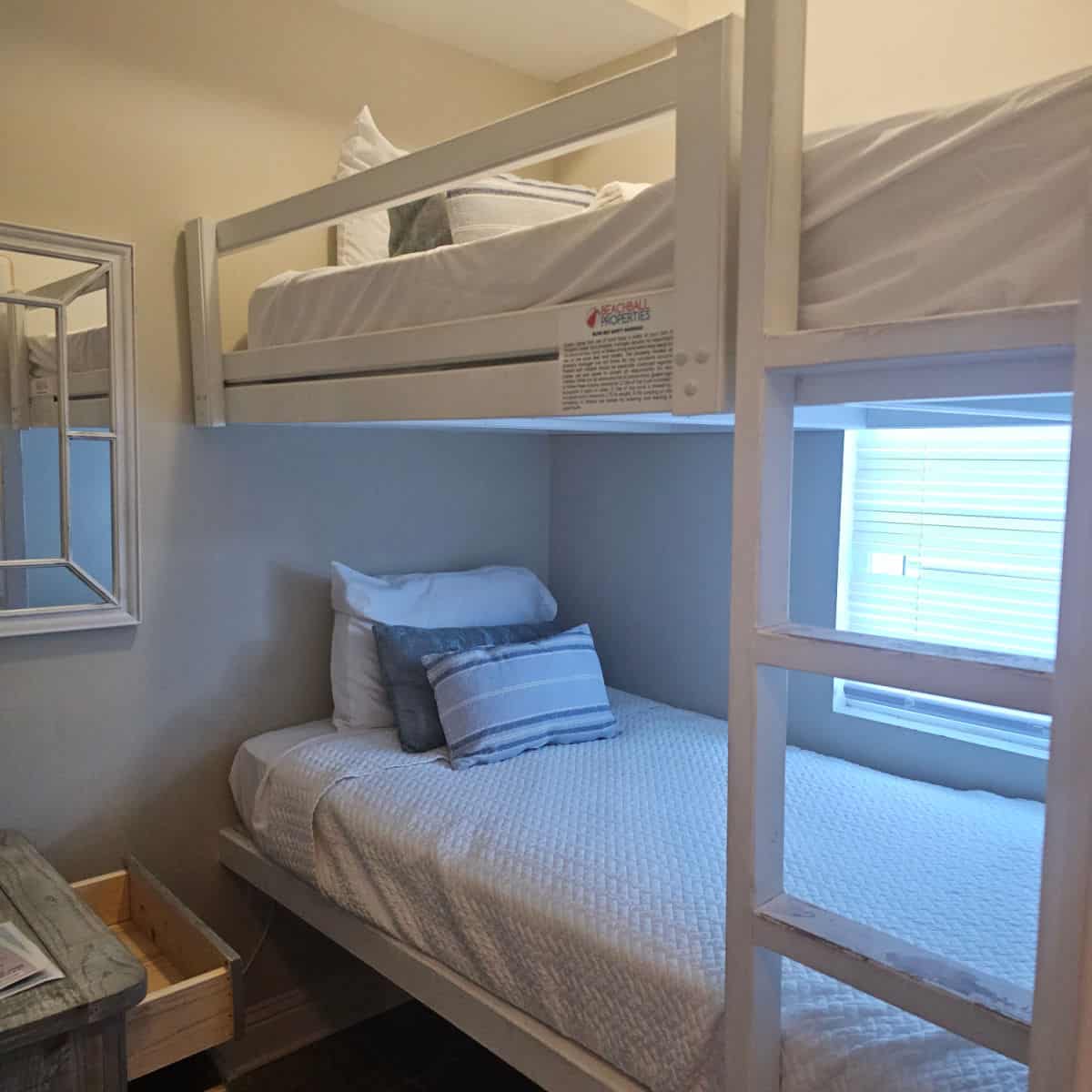 bunkbeds with white linens, pillows on the bunk bed