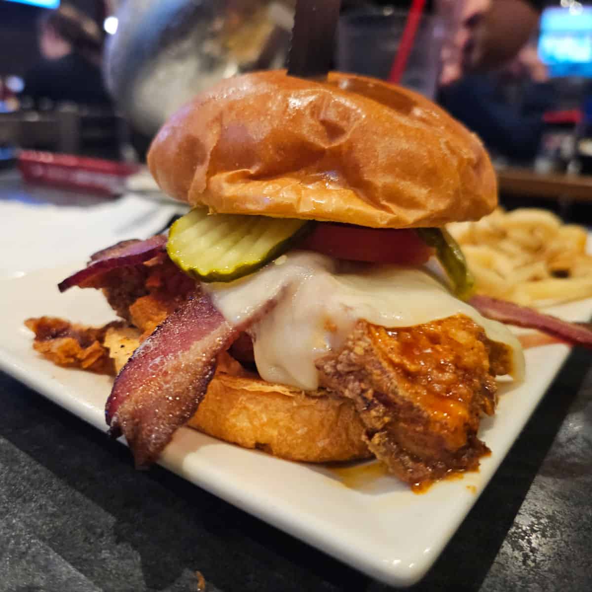 Royal Rooster Chicken Bacon sandwich on a white plate with fries