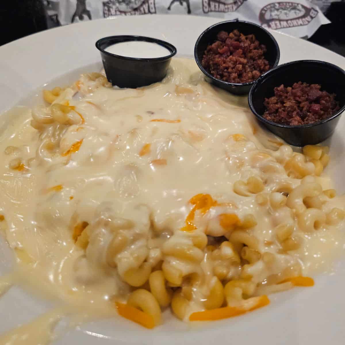 mac and cheese in a white bowl with sides of bacon and ranch