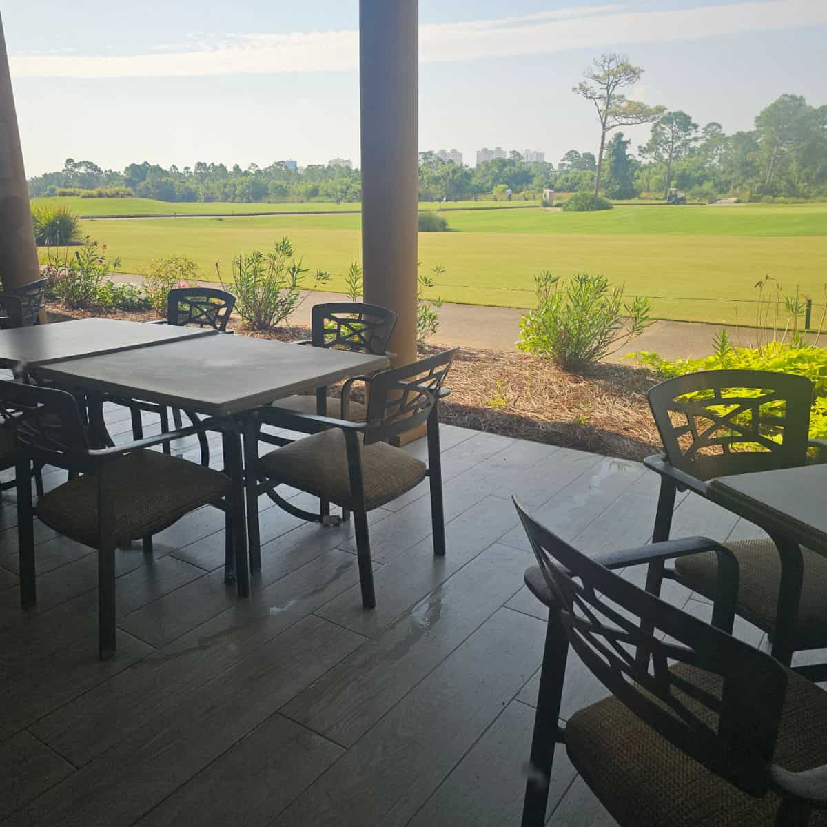 Outdoor seating overlooking the Lost Key golf course with tables and chairs under an awning