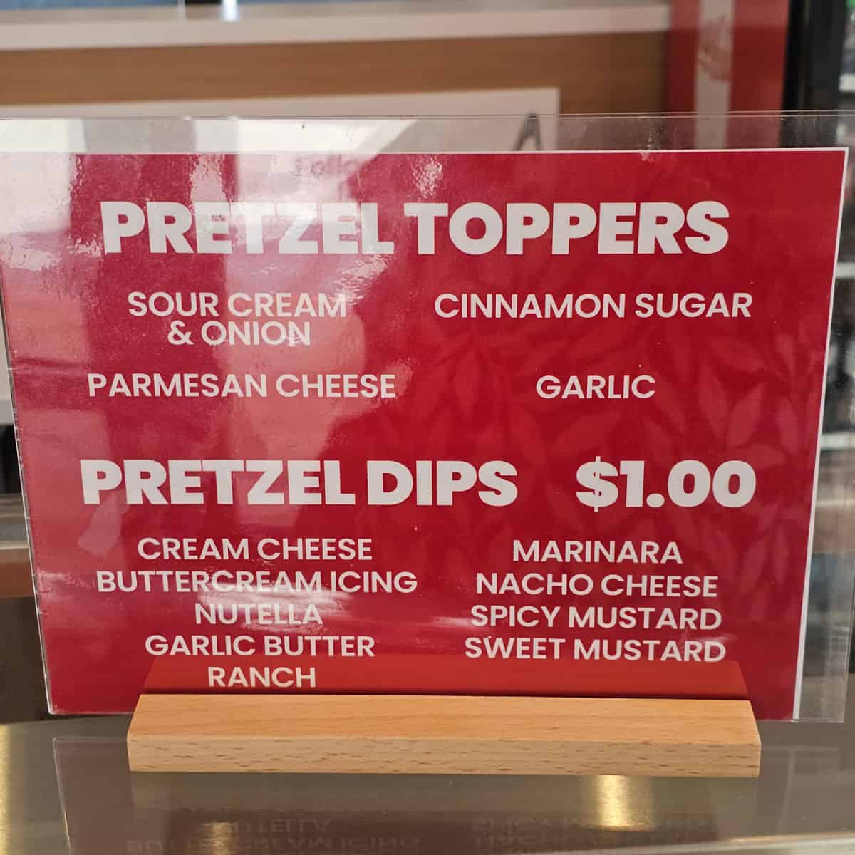 Pretzel Toppers and Pretzel Dips menu in a holder on the counter