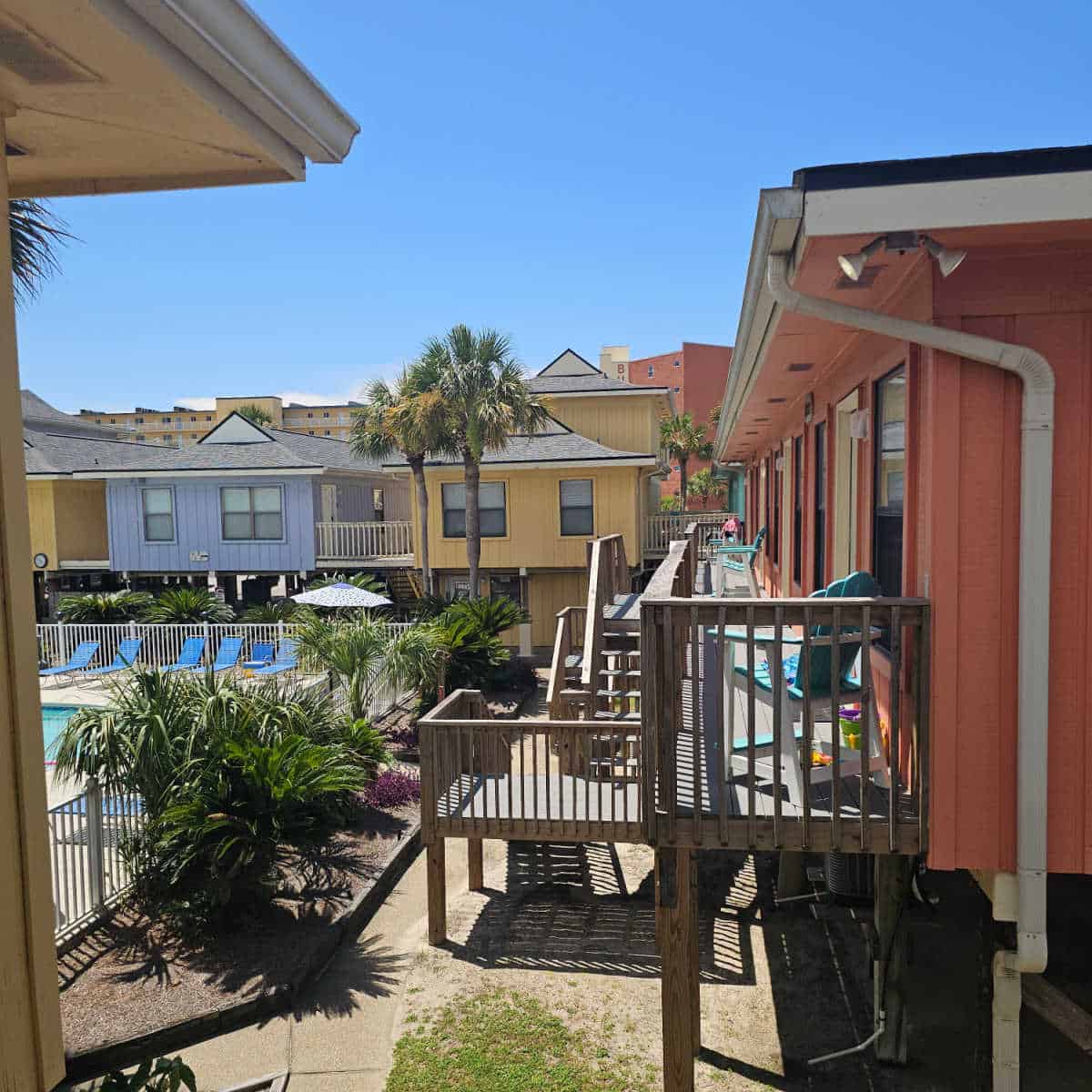 Colorful raised villas looking over the pool deck on a sunny day