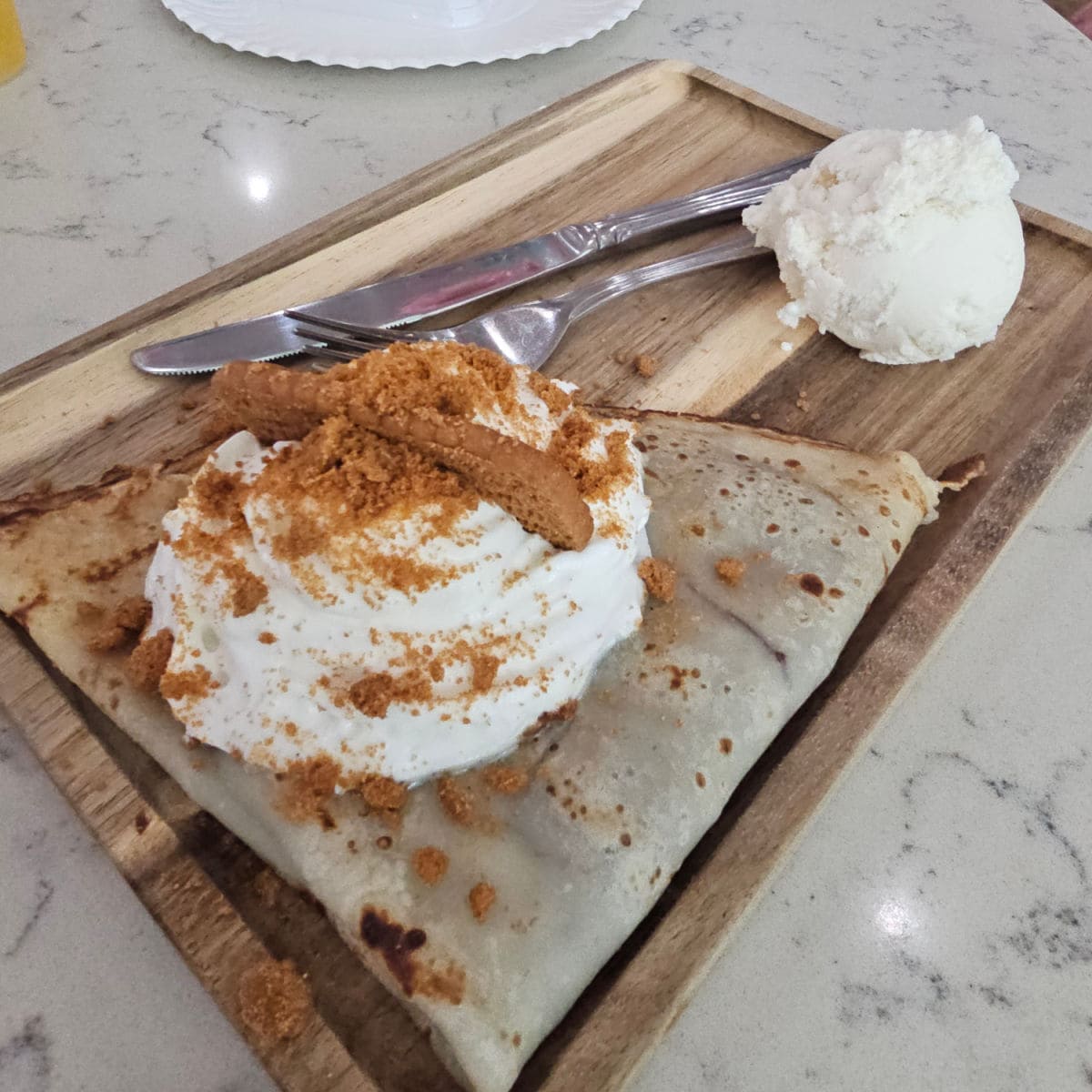 nutella and biscoff crepe on a wooden boards with ice cream
