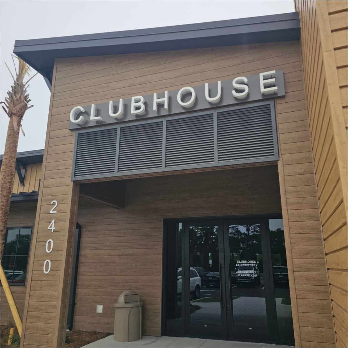 clubhouse sign on a brown wooden building with glass entrance door