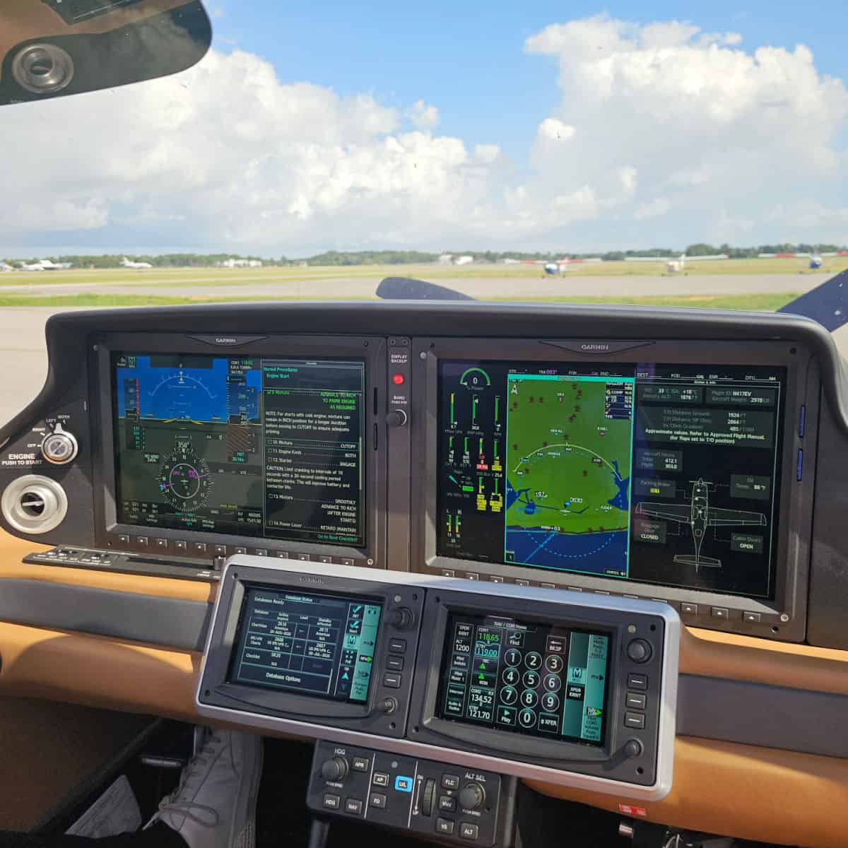 Plane dashboard and windshield looking towards planes and clouds
