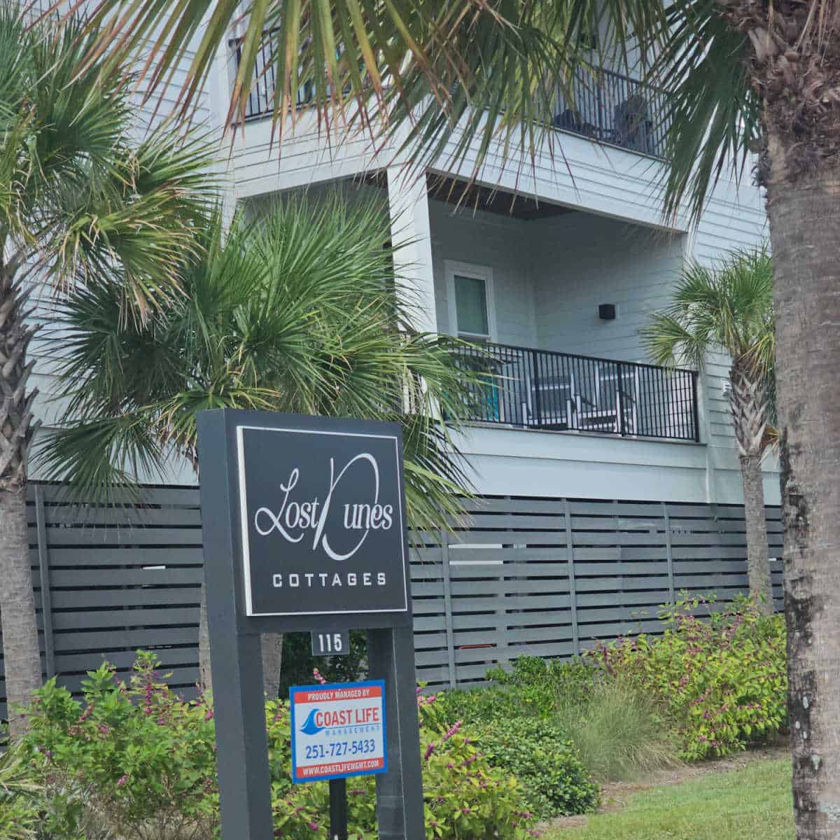 Lost Dunes Cottages black and white sign in front of the two story cottages