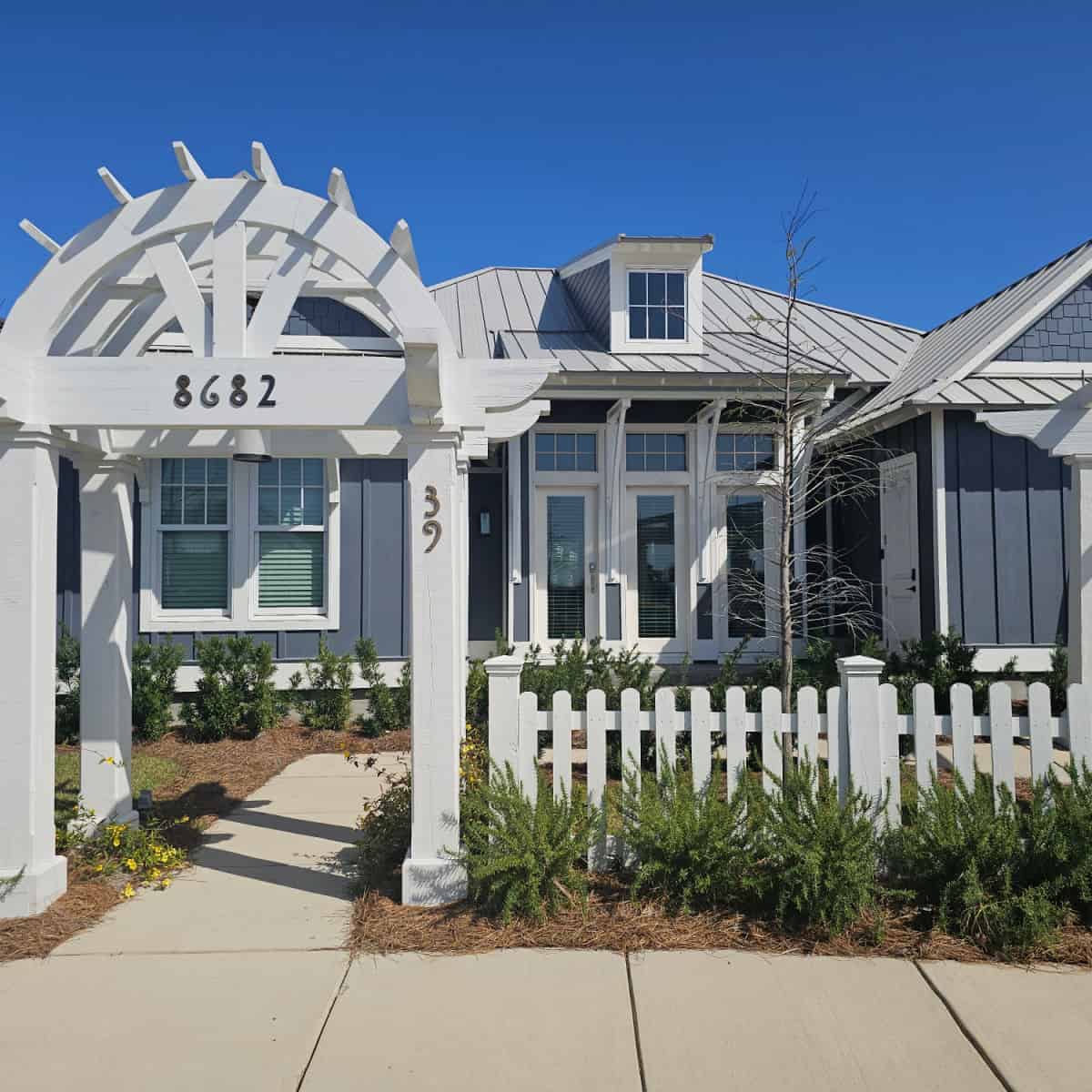 Exterior of Cottage 39 with white fence, blue cottage with lots of windows