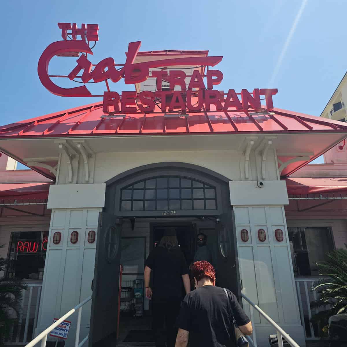 The Crab Trap Restaurant sign in red above a white building