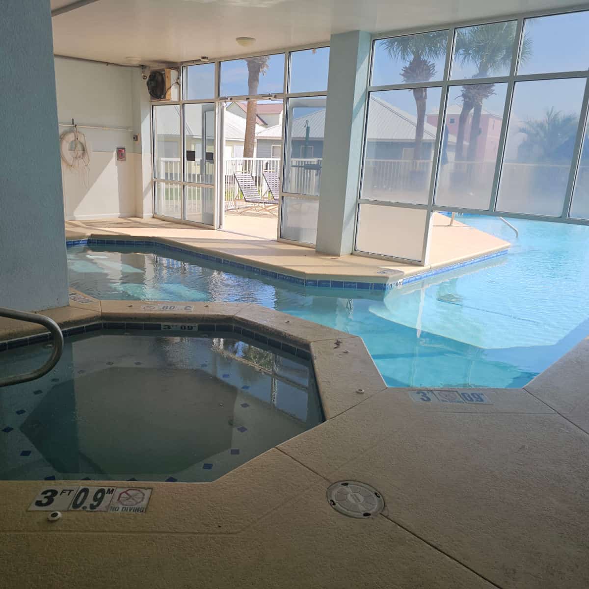 hot tub next to an indoor pool connected to the outdoor pool with a swim-through area