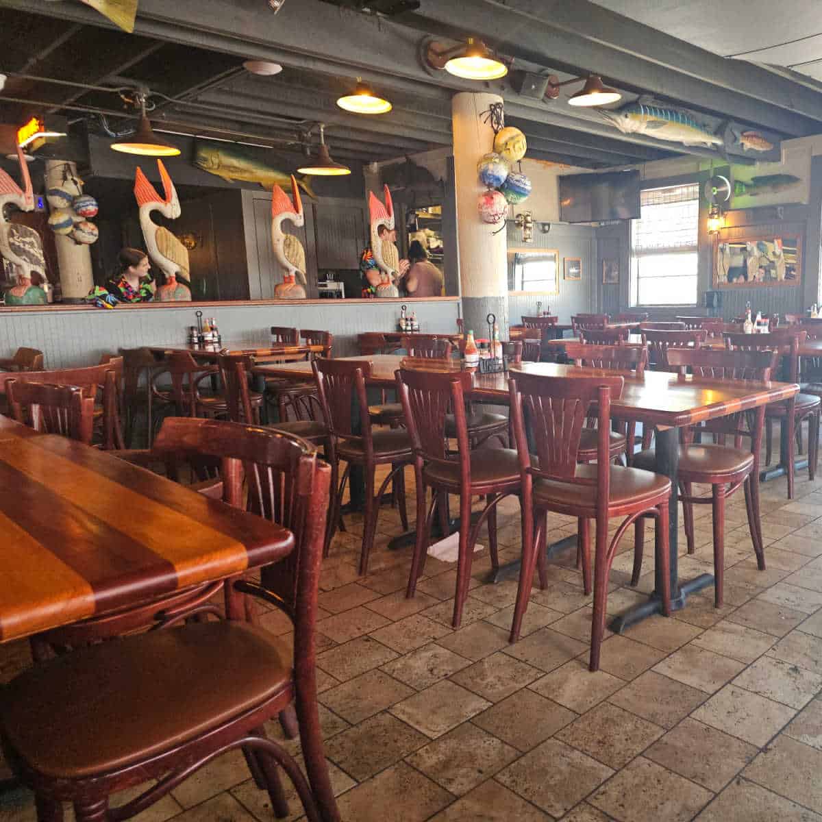 Cozy oceanfront-inspired dining room with wooden tables and chairs.