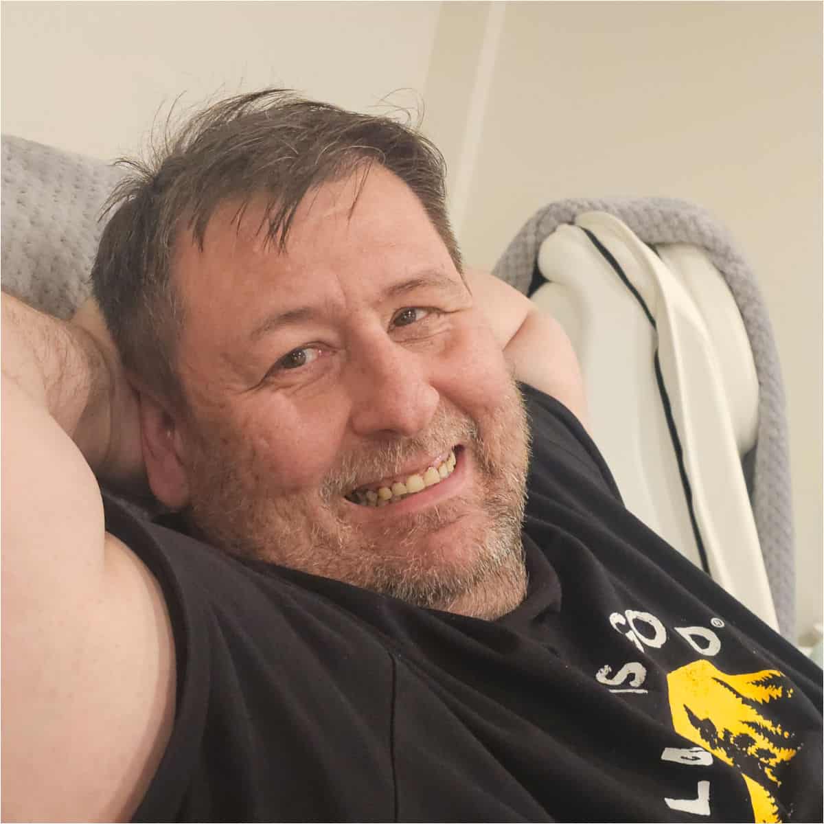 john smiling in a pedicure chair with his hands behind his head