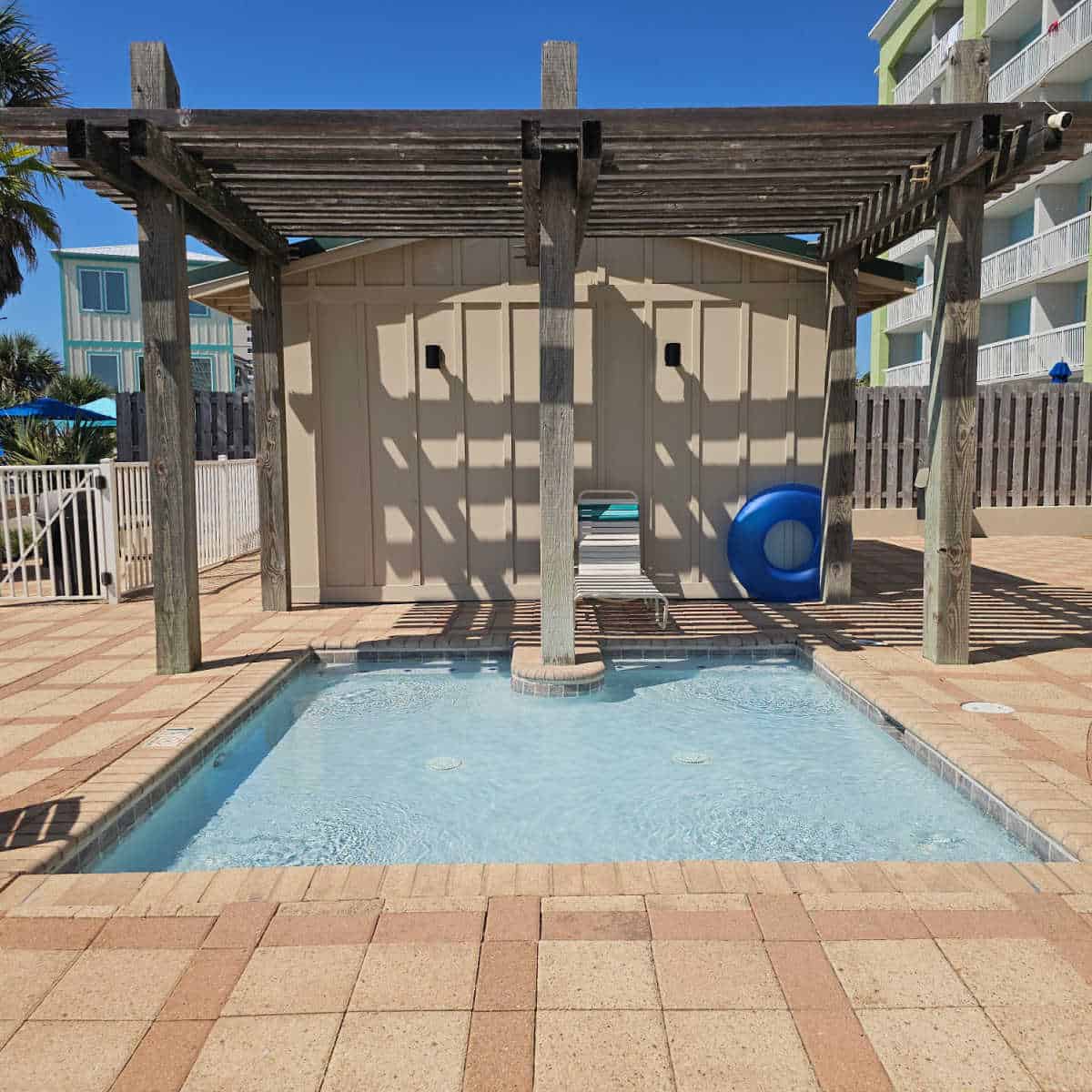1 ft kiddie pool near a pergola with a lounge chair