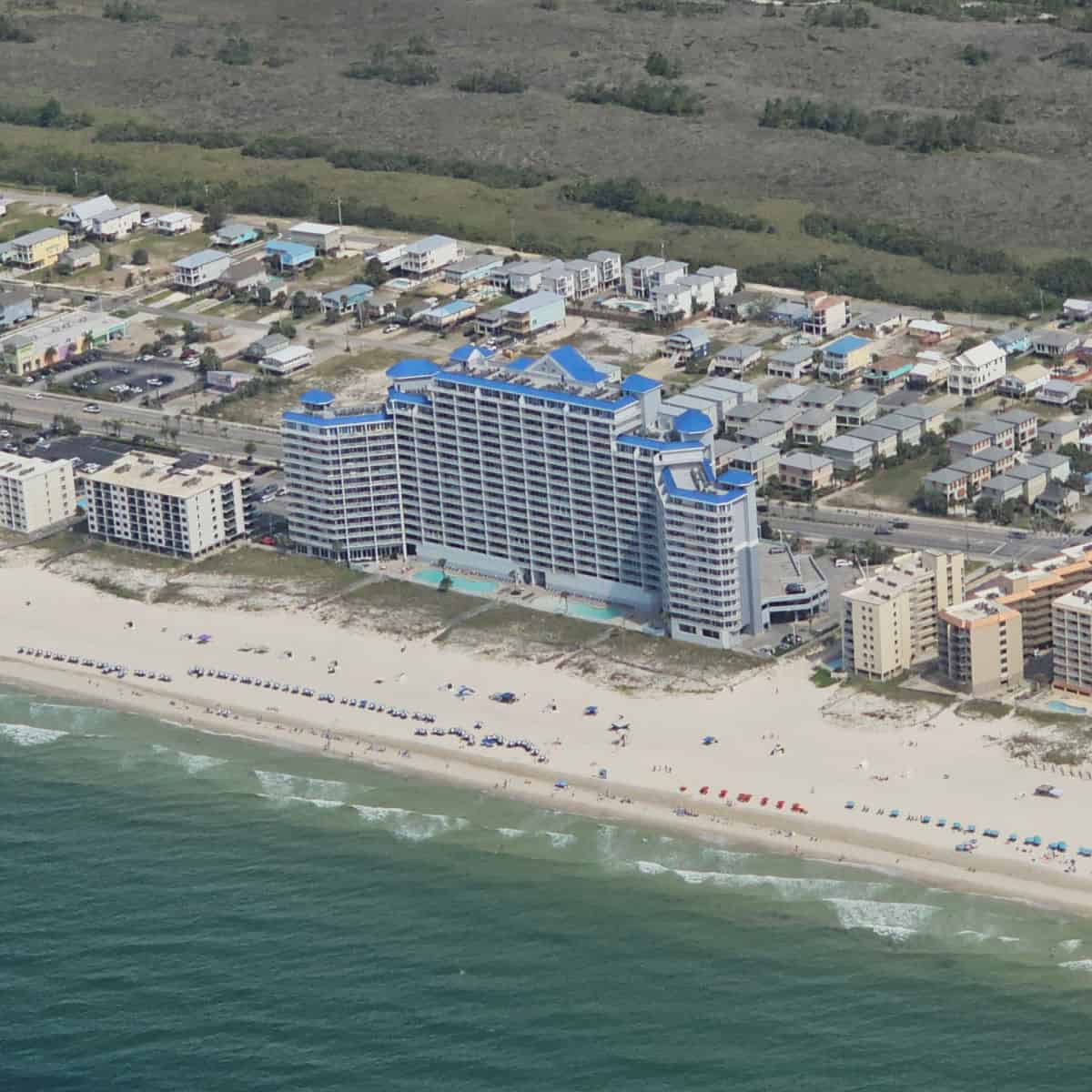 The Lighthouse Condo building with buildings around it, beach views from the air