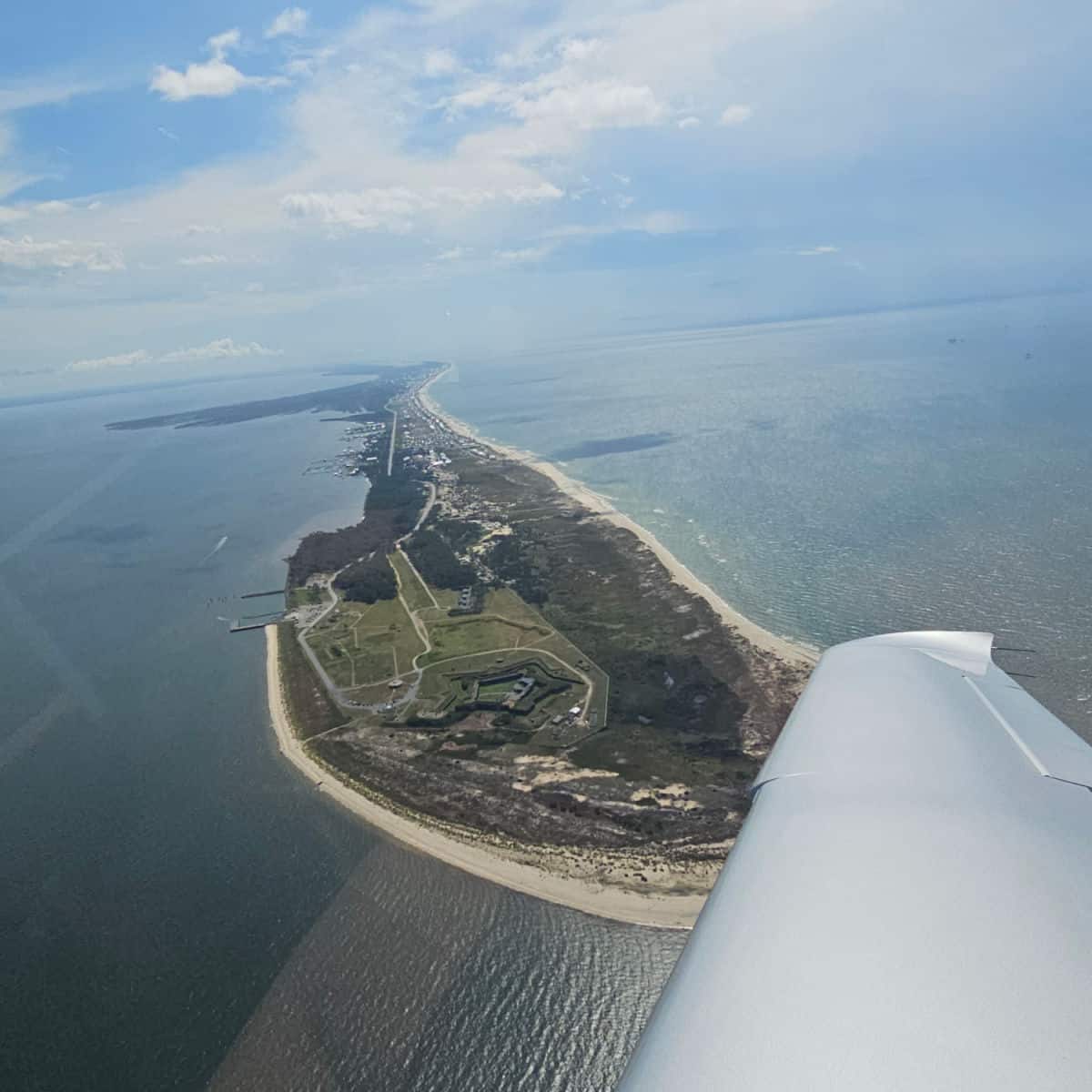 Looking over a plane wing to Historic Fort Morgan and down the island towards Gulf Shores