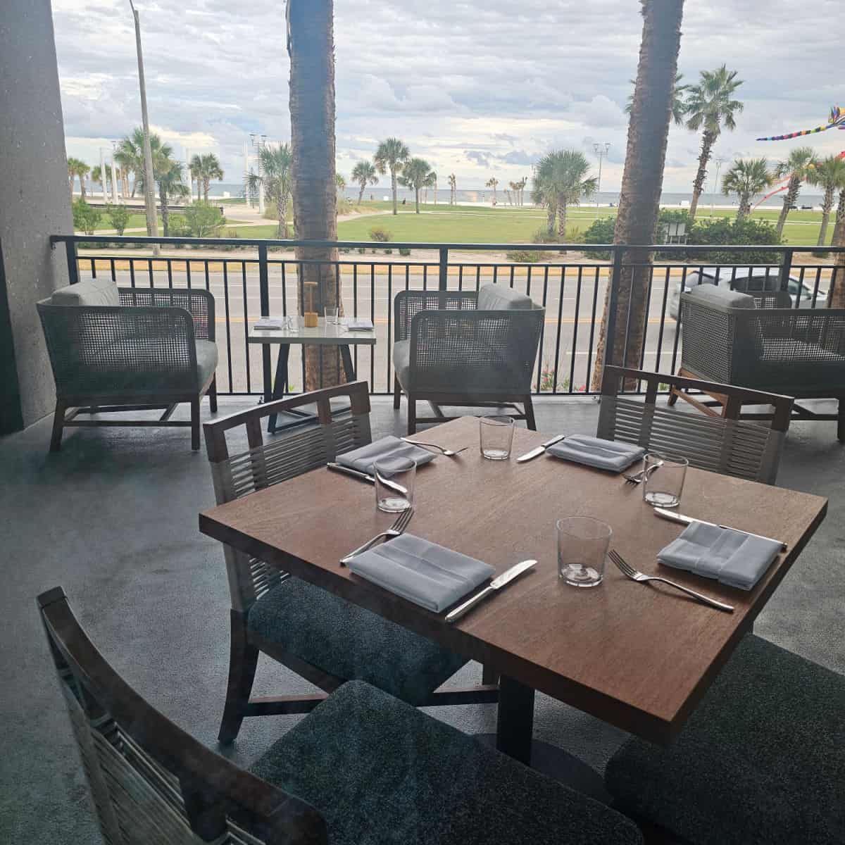 outdoor seating with tables and chairs, looking towards gulf place beach and the Gulf