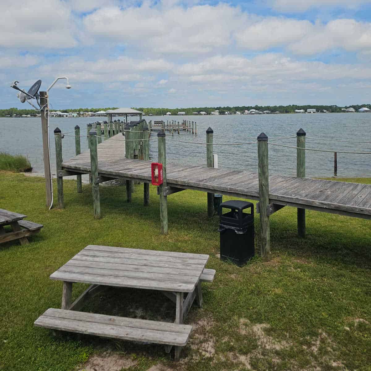 wooden pier out to Little Lagoon with bench seats and a covered area, picnic table next to the boardwalk