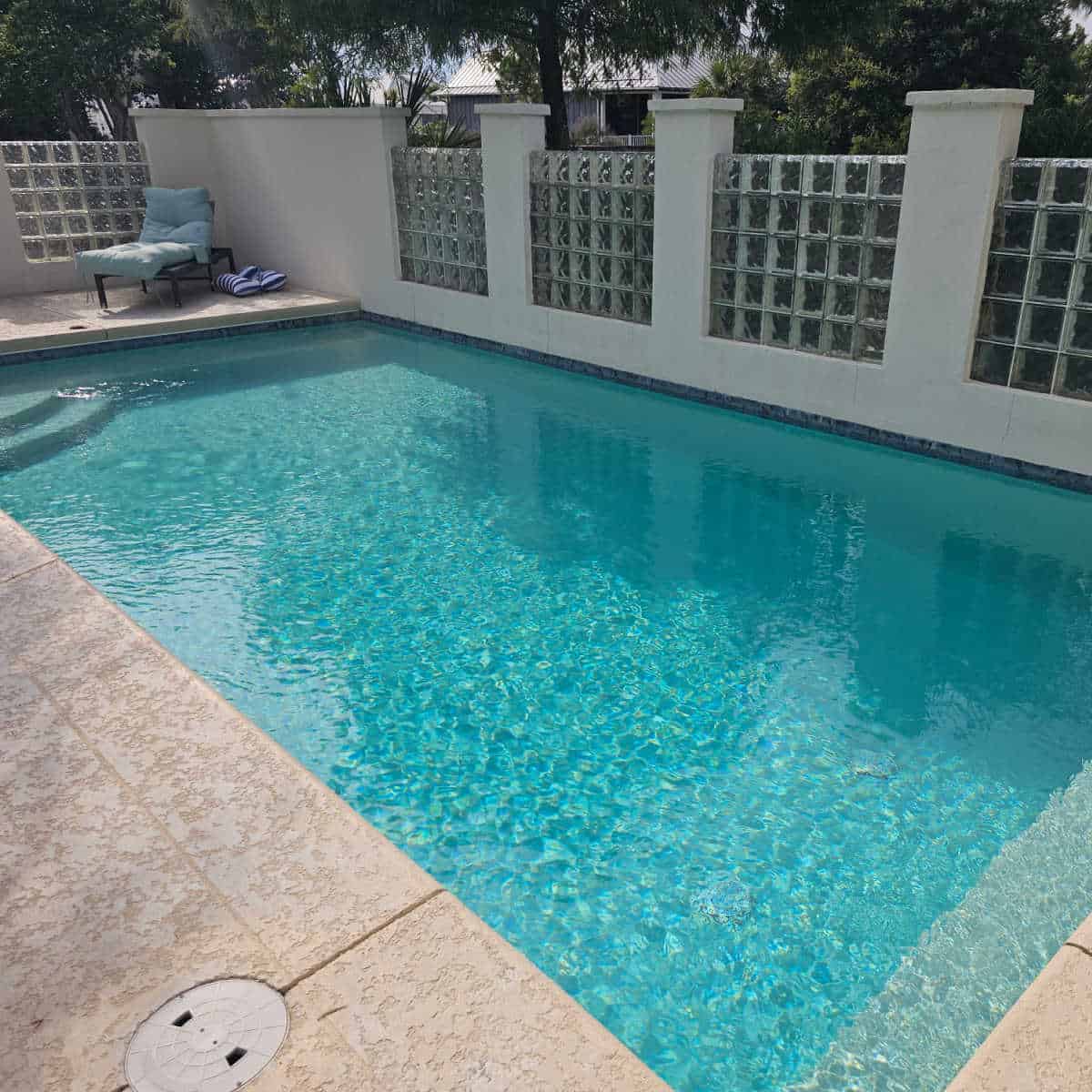 Private pool with glass wall, lounge chair in the corner
