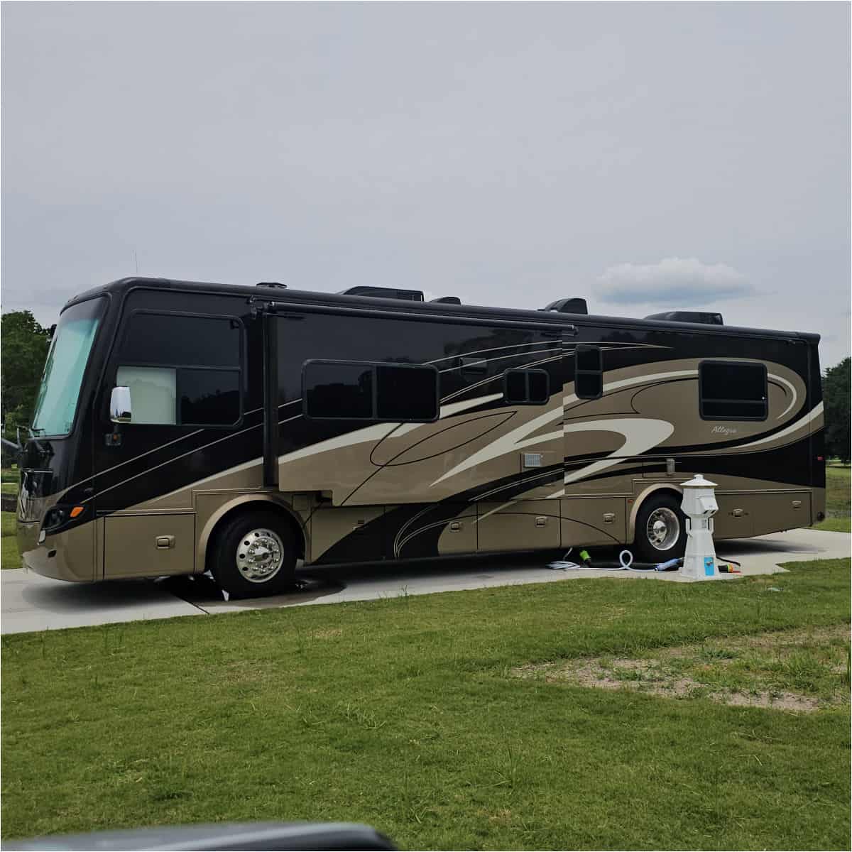Large RV backed into a campsite with a hook up area next to it