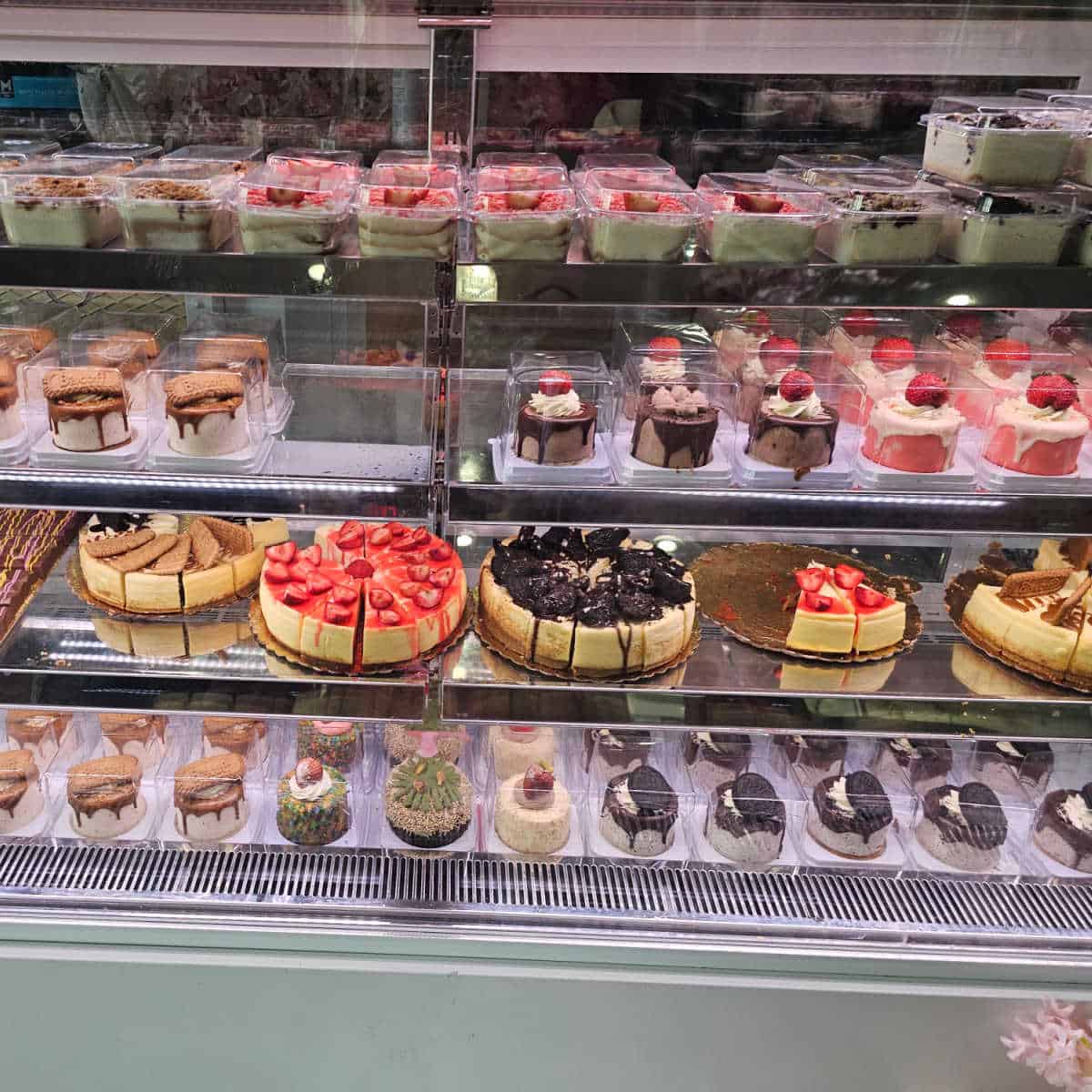 bakery case with cheesecakes full size and mini, mini cakes and layered desserts