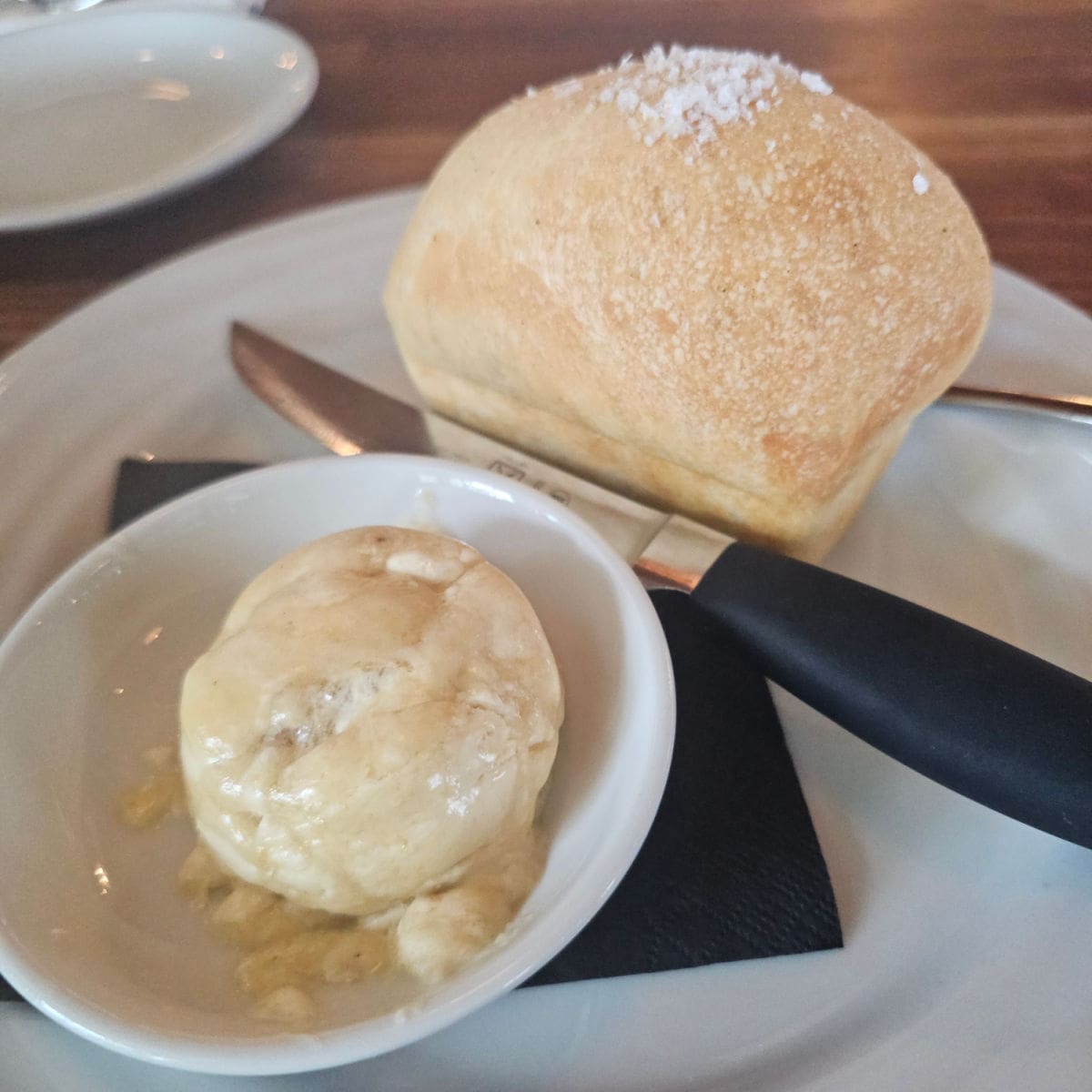 focaccia bread roll with a knife and bowl of brown butter