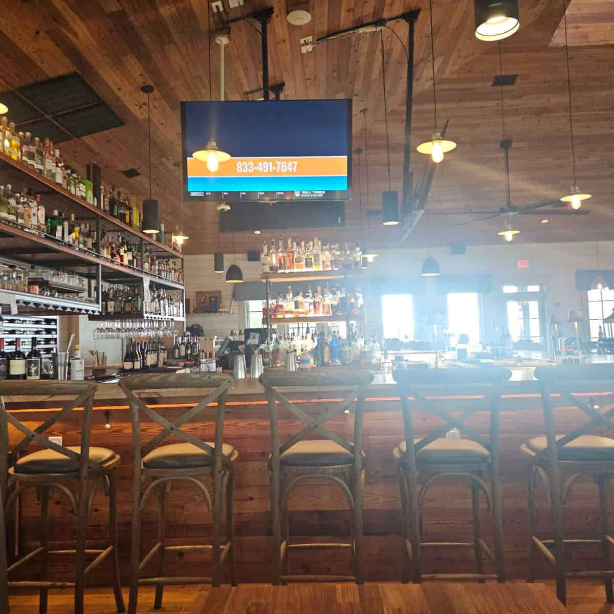 bar seating with light shining in through the far windows