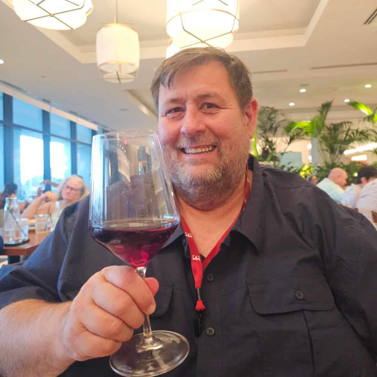 John holding a glass of red wine