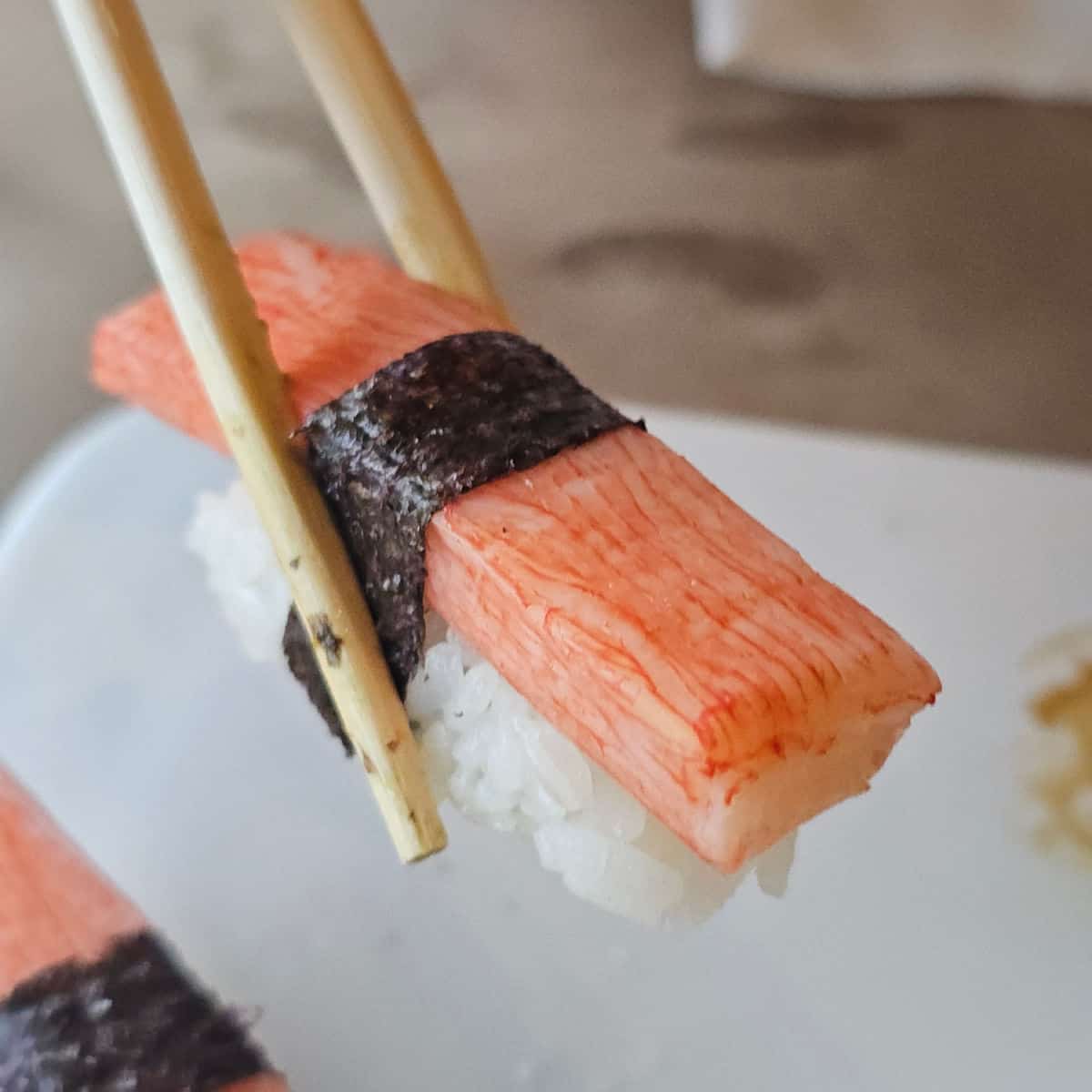 Kani Nigiri being held with chopsticks
